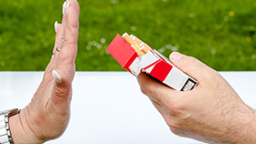 A hand blocking the offer for cigarettes.